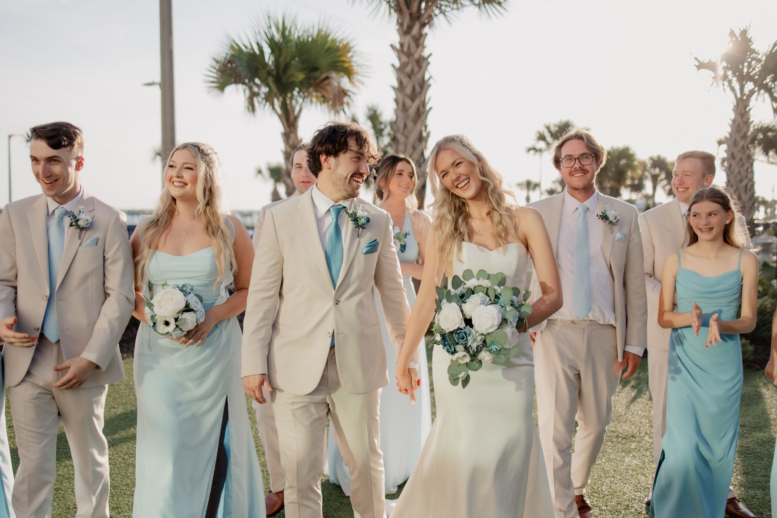 Emily and Michael’s wedding party walking at Embassy Suites Panama City Beach, captured by White Sands Weddings photo and video team.