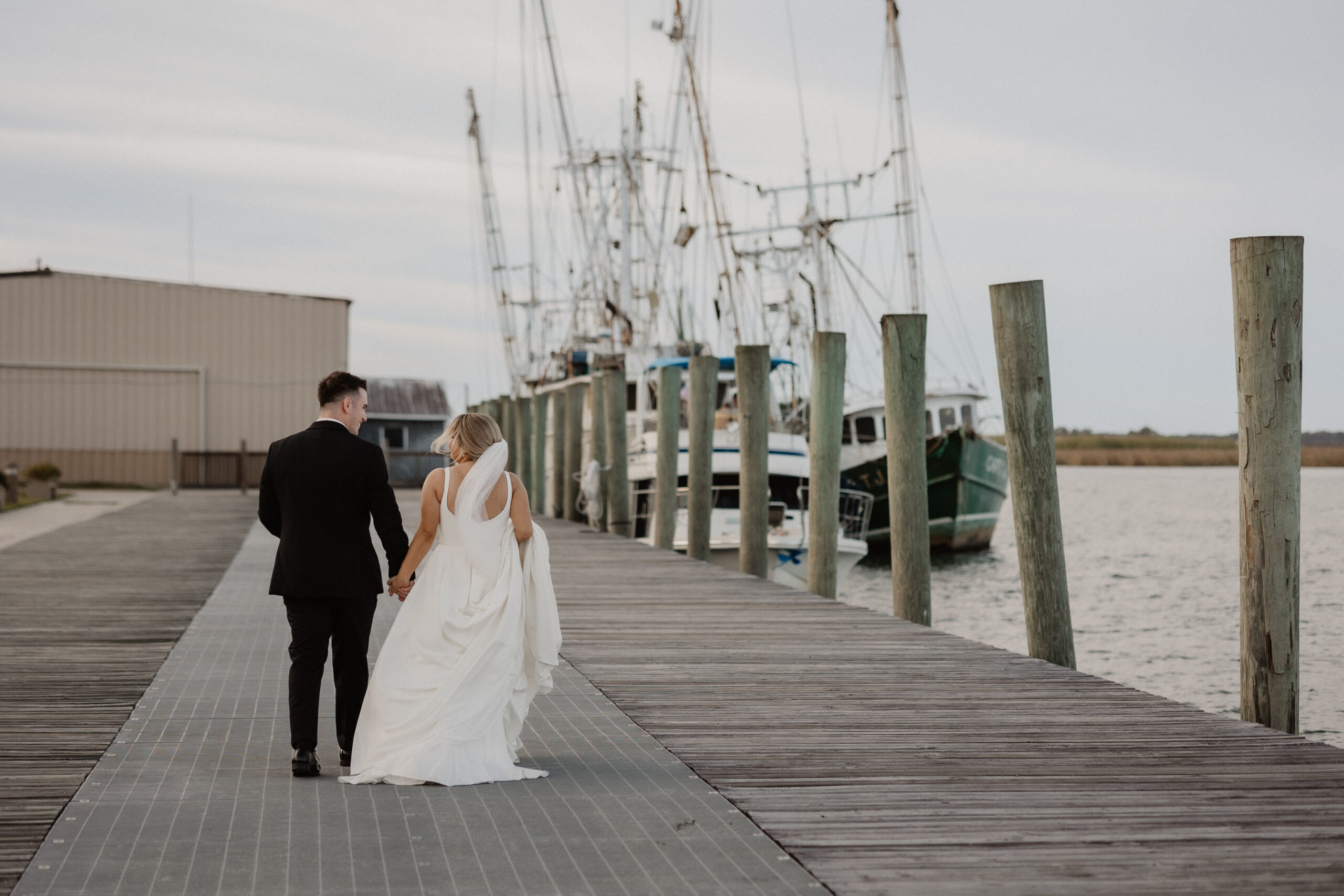 Portrait of the groom waiting on a Gulf Coast pier before his waterfront wedding ceremony.